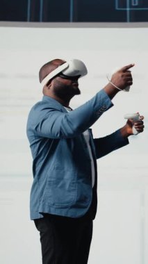 Dikey Video Afrikalı Amerikalı programcı, bir kulaklıkla sanal gerçekliğe bağlanıyor, sistem geliştirmeye odaklanıyor. Yeni yazılım hata ayıklamak ve tasarlamak için terminal penceresinde kod kullanılıyor. IT kariyeri