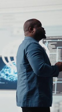 Yenilik için programlama diline odaklanan Dikey Video Siyah yazılım uzmanı, terminal penceresinde ikili kod okuyor. Veri bilimi için kod geliştirmeyi gözden geçirir. Modern gelecekçi kodlama hayatı