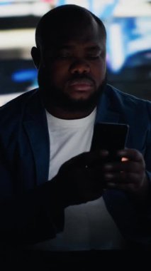 Dikey Video Modern Adam elinde telefonunu tutarak sosyal medyanın aşırı kullanımının zararlı etkilerini ifade ediyor, sosyal kaygı ve zihinsel sağlık sorunlarını temsil ediyor. Gerçek dünyadan izolasyonu gösteriyor. Kamera B.