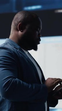 Yüksek teknolojili bir iş ortamı için yazılım geliştirmeye çalışan dikey video Afrikalı Amerikalı kodlayıcı uzmanı, dizüstü bilgisayar ekranına odaklanmış. Mühendis hayatı kodlamak ve bilişim bulut hesaplamasından zevk alıyor. Kamera.