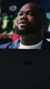 Dikey Video Afrikalı Amerikalı uzman medya gösterge panelleri ile ilgileniyor, yapay zeka ve teknolojiyle ağı vurguluyor. Teknoloji güdümlü adam online platformlar ve internet iletişimi sergiliyor