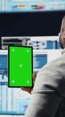 Dikey Video Afrikalı Amerikalı lider, fintech grafikleri ve KPI projeksiyonları ile çevrili iş geliştirme için veri içgörüsüyle model ekranını inceliyor. Mali performans ve karar verme