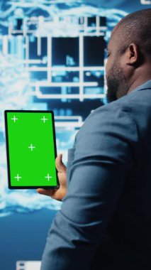 Dikey Video Afrikalı Amerikalı uzman, bulut hesaplama sistemlerinin yanında izole ekranlı tablet tutuyor, yapay zeka beyin gelişimi ve inovasyon için makine öğrenimi üzerine odaklanıyor. Akıllı teknoloji veri bilimi