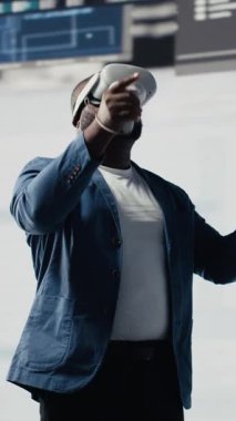 Dikey Video Afrikalı Amerikalı programcı, bir kulaklıkla sanal gerçekliğe bağlanıyor, sistem geliştirmeye odaklanıyor. Yeni yazılım hata ayıklamak ve tasarlamak için terminal penceresinde kod kullanılıyor. IT kariyeri