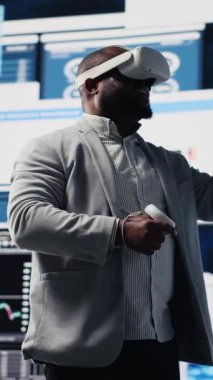 Dikey Video Genç girişimci yöneticisi, büyük verileri sanal gerçeklik kulaklığıyla inceleyerek, kazancı artırmak için iş büyümesi üzerinde sıkı çalışıyor. Üretim ve başarı için aylık raporlar analiz ediliyor