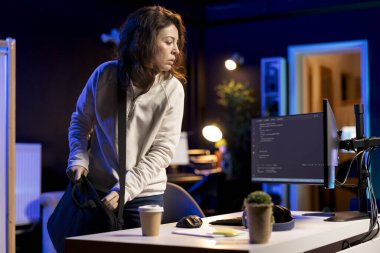 Sistem yöneticisi ofise geliyor, dizüstü bilgisayardaki yazılım uygulamalarını tasarlamaya ve geliştirmeye hazır. IT uzmanı iş vardiyasına başlıyor, dizüstü bilgisayarları açıyor, şirket sistemlerini uyguluyor ve devam ettiriyor