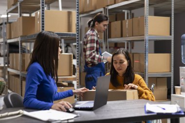 Engelli bir kadın, küçük işletme ve yerel dağıtım için tatmin merkezinde çalışıyor. Hareket kabiliyeti düşük, kutuları hazırlayan ve nakliye lojistiği ile uğraşan bir çalışan..