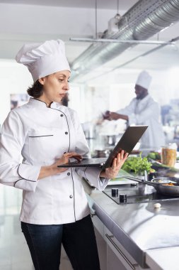 Aşçı gurmeleri, restoran mutfağı, teknoloji ve geleneği dengelemek için dizüstü bilgisayar ve bahşiş kullanan adanmış kadın şef. Sebze ve hammadde doğrama uzmanı..
