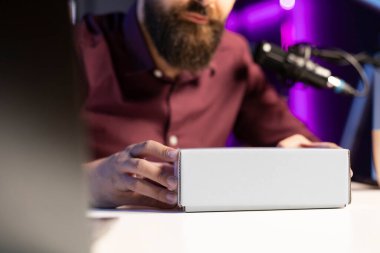 Teknoloji vlog 'u için teknoloji gurusu tarafından açılmaya hazır paketlenmiş ürünlerin yakın çekim görüntüleri. Etkilenen taraftar tarafından desteklenen ve destekleyen ortak ürünleri satın almaya teşvik edilen kutuya odaklan