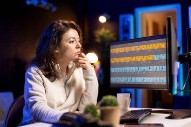 Fotoğraf editörü masaüstü bilgisayarındaki düzenleme yazılımıyla fotoğrafları rötuşluyor, düzeltilmesi gereken resimler bulmak için fotoshoot çekimlerini tarıyor. Merkez ofisteki fotoğrafçı resimleri ayarlıyor