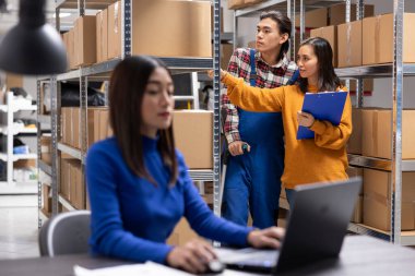 Asyalı bir çalışan depoya girip dağıtım emirlerini yerine getirmek için koltuk değneklerini kullanıyor. Yerel dağıtımı, iş lojistiğini ve erişilebilir depo operasyonlarını destekleyen küçük işletmeler.