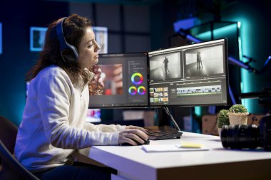 Videograf, bazı müziklerle rahatlarken video projeleri için görsel efektler yaratmak için yazılım kullanır. Profesyonel kulaklık takıyor. Ham görüntüleri düzenlemek için post prodüksiyon teknikleri kullanıyor.