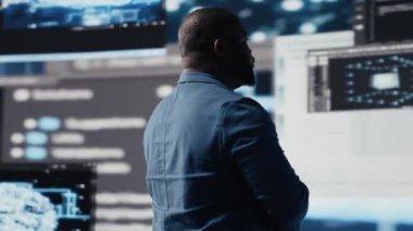 Yapay zeka programlama dili ve veri bilimi ile siber ortamda çalışan Afrikalı Amerikalı geliştirici. Teknisyen kod geliştirmeyi, yenilik otomasyonunu sembolize eder. Teknoloji dünyası. Kamera B.