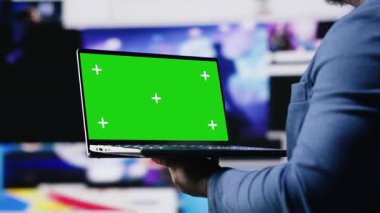 Modern siyah arayüz kullanıcısı, dijital ekran ve uygulamalardan oluşan yeşil ekranlı bir cihaz tutuyor, yapay zeka ve fintech 'in entegrasyonunu vurguluyor. İletişim ve içerik oluşturma. Kamera B.