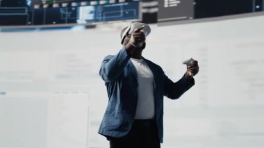 Afrika kökenli Amerikalı programcı sanal gerçekliğe bir kulaklıkla bağlanıyor, sistem gelişimine odaklanıyor. Yeni yazılım hata ayıklamak ve tasarlamak için terminal penceresinde kod kullanılıyor. Bilişim kariyeri. Kamera B.