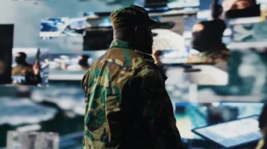 Savaş alanı detaylarıyla savaş planlama taktikleri üzerinde çalışan, bir kontrol merkezinde uydu verilerini inceleyen siyah bir erkek asker. Ulusal güvenlik için yüksek teknoloji ordu ortamı. Kamera B.