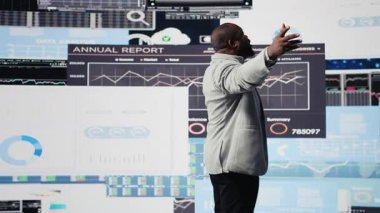 Siyahi lider verimli yönetim kararlarında finans modellerini geliştirmek için dijital grafikler ve analizler kullanıyor. Teknoloji zekasıyla performansı optimize eden profesyonel bir adam, Fintech. Kamera A.