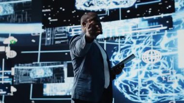 Afrika kökenli Amerikalı mühendis bulut hesaplama araçları ve gelişmiş programlama kullanarak yapay zeka beyin sistemlerini inceliyor. Sanal asistan otomasyonu için makine öğrenimi kullanılıyor. Kamera B.