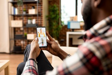 Serbest çalışan siyahi bir adam potansiyel yatırımcılarla görüşmek için cep telefonunu kullanıyor. Afrika kökenli Amerikalı girişimci, beyaz muhasebecilerden mali danışmanlık talep ediyor..