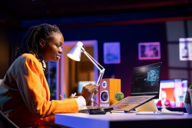 Geliştirici dizüstü bilgisayarda kod yazıyor ve yapay zeka sinirsel ağlarının bakımını yapıyor. Bilgisayarlı model. Klavyede yazan teknik destek uzmanı, ev ofisteki yapay zeka sistemlerini kontrol ediyor.