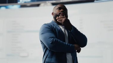 Otomasyon için programlama dilini analiz eden Afro-Amerikan mühendis, arkasında geleceksel bir arayüzü olan veri bilimi. Erkek teknisyen yapay zeka ve kod parçacıklarıyla başarılı oluyor. Kamera B.