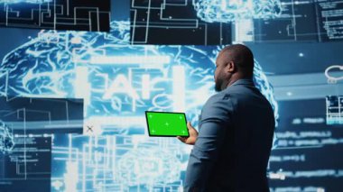 Afrika kökenli Amerikalı mühendis, veri işleme otomasyonu ve yenilikleri için öngörücü analitikleri ve nöral ağları inceleyen, izole edilmiş görüntülü bir tablet gösteriyor. Sibernetik. Kamera A.