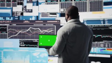 Siyah yönetici, sanal grafikler ve tahmin modelleriyle çevrili, iş büyümesi için veri içgörüsüyle fotokopi ekranını inceliyor. Finansal performans ve karar verme. Kamera A.