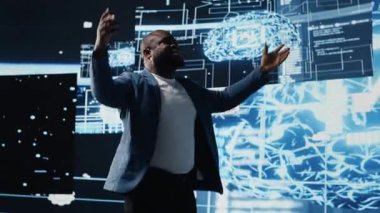 Siyah bilişim teknisyeni yapay zeka sistemleri için canlı bir sunum sunuyor, öngörü analizleri ve otomasyon hakkında bilgi veriyor. Yapay Zeka Kongresi 'nde erkek konuşmacı. Kamera B.