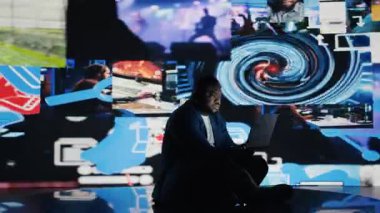 Siyah kullanıcı, bağımlılık ve hasardan kaynaklanan sosyal kaygıları sembolize ediyor, çevrimiçi içerik ve cep telefonu kullanımının ezici etkisinden muzdarip. Akıl sağlığı sorunları. Kamera A.