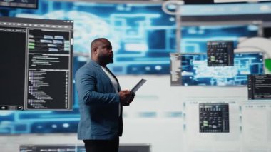 Programlama ve otomasyon üzerine çalışan Afro-Amerikalı geliştirici arkasında gelecekteki arayüzü olan bir dizüstü bilgisayarda kodlama yapıyor. Teknoloji profesyoneli yapay zeka ve kod parçalarından oluşan bir dünyada gelişiyor. Kamera A.