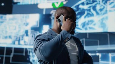 Siyah girişimci insanlarla iletişim kurmak için cep telefonu araması yapıyor, sibernetik platformlar ve yapay zeka arayüzleri hakkında bilgi paylaşıyor. Makine öğrenimi ve büyüme için öngörücü analiz. Kamera A.