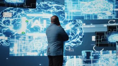 Afro-Amerikalı iş adamı dijital yapay zeka arayüzü üzerinde çalışıyor, sinirsel ağları, veri bilimini ve algoritmik düşünceyi sembolize ediyor. Yüksek teknolojili bir yenilik için sibernetik. Kamera A.