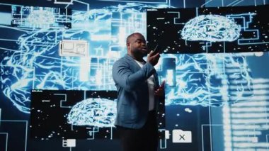 Genç siyahi iş adamı telefonla konuşuyor, yapay zeka sistemleri ve makine öğrenimi hakkında bilgi paylaşıyor. IT mühendisi sinirsel ağlar hakkında konuşuyor. Kamera A.