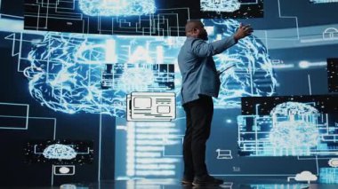 Afrikalı Amerikalı bilişim uzmanı izleyiciler için yapay zeka sistemleri sunumuna ev sahipliği yapıyor, mikrofondan veri görselleştirme ve makine öğrenme algoritmaları hakkında konuşuyor. Toplum içinde konuşma. Kamera A.