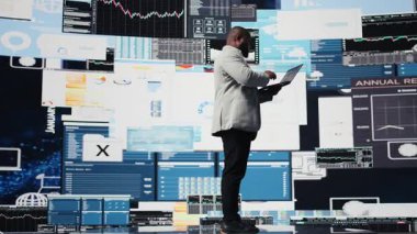 Siyahi profesyonel yönetici dijital gösterge panelini finans grafikleriyle inceliyor. Stratejik planlama üzerinde çalışıyor. Kurumsal ekonomi yönetimi. Kamera A.
