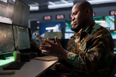 Terörizm karşıtı operasyon yürüten, tabancaya kurşun sıkan, düşman kuvvetlerine saldırmaya hazırlanan bir ajan. Afrika kökenli Amerikan askeri, saldırı görevine hazırlanıyor.