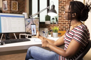 Kafkas doktoruyla sanal görüşmede kadın veri analisti hastanenin dijital sistemindeki güncellemeleri tartışıyor. Sağlık hizmetleri veritabanı oturumu sırasında doktorla video görüşmesi yapan siyahi bir kadın.