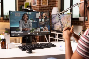 Kadın girişimci evden çalışır, çeşitli iş ortaklarıyla sanal tartışmalara girer. Afrikalı Amerikalı bir kadın tuğla duvar odasında masa başında oturmuş bilgisayar eğitimi alıyor.