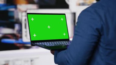 Afro-Amerikan uzman dijital arayüzler ve multimedya görsellerinin yanında fotokopi alanı gösteriyor, içerik oluşturma, mobil teknoloji ve küresel çevrimiçi etki sergiliyor. Kamera B.