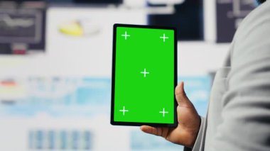 Girişimci analiz için krom anahtarlı tablete bakar, aylık raporları ve şirket gelişimi için bilgi grafiklerini gözden geçirir. Büyüme ve tahmin için iyi performans ölçümleri. Kamera B.