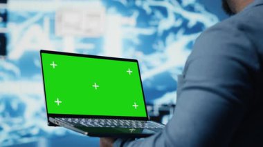 Siyah yüksek teknoloji mühendisi, sanal zeka ve platform yenilikleri için öngörücü analitik ve sinir ağları sistemlerini inceleyen izole edilmiş ekranlı telefonu tutuyor. Kamera B.