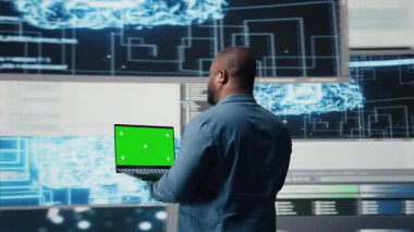 Siyah mühendis dizüstü bilgisayarında kroma anahtarı olan ikili kod üzerinde çalışıyor. Teknoloji dünyasının zihniyetini yansıtıyor. Programlama dilleri ve geliştirme araçları olan icat merkezi, yaşam kodlaması. Kamera A.