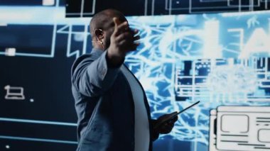 Afrikalı Amerikalı bilişim uzmanı izleyiciler için yapay zeka sistemleri sunumuna ev sahipliği yapıyor, mikrofondan veri görselleştirme ve makine öğrenme algoritmaları hakkında konuşuyor. Toplum içinde konuşma. Kamera B.