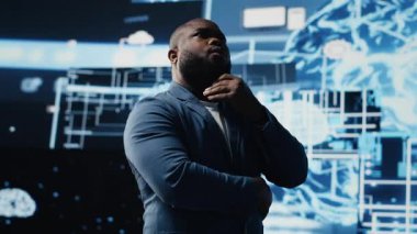 Siyah erkek uzman yapay zeka araştırmalarında veri yapıları veya platformlar ve akıllı teknoloji sistemleri ile etkileşim içinde. Derinlemesine öğrenim, bulut hesaplama ve öngörücü analitik çalışmaları yapıyor. Kamera B.