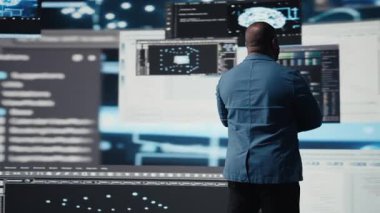 Yapay zeka programlama dili ve veri bilimi ile siber ortamda çalışan Afrikalı Amerikalı geliştirici. Teknisyen kod geliştirmeyi, yenilik otomasyonunu sembolize eder. Teknoloji dünyası. Kamera A.