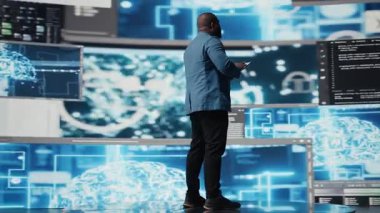 Fütürist dijital çalışma alanında, siyah geliştirici programlama yazılımı ve kod parçacıkları keşfediyor. Teknoloji profesyoneli yenilik, siber güvenlik, otomasyon ve geliştirmeyi somutlaştırır. Kamera A.