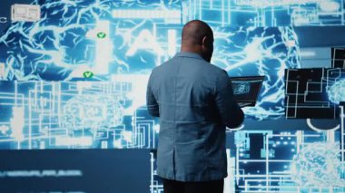 Teknolojiden anlayan siyah mühendis yapay zekanın beyin veri görselleştirmesi ile çalışıyor, derin öğrenme için bilgisayar bilimi ve otomasyon araçlarını gösteriyor. Sinir ağı sistemleri uygulanıyor. Kamera A.