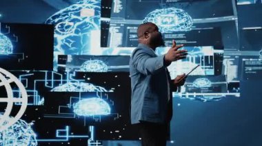 Afrika kökenli Amerikalı erkek uzman derin öğrenme yapay zeka sistemleri sunuyor, otomasyon ve sinirsel ağlar için robotları güvence altına alıyor. Genç profesyonel sunucu. Kamera A.