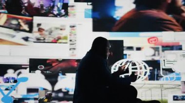 Elinde aşırı sosyal medya etkileşiminin, sosyal kaygının ve dijital dünyadaki izolasyonun zararlı etkilerini gösteren bir cihaz tutan siyah bir adam var. Manipülasyon ve paranoya gösteriyor. Kamera A.