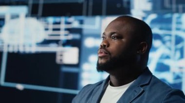 Afrika kökenli Amerikalı bilişim uzmanı yapay zeka arayüzünü inceliyor, makine öğrenme algoritmalarını cihazlarla gösteriyor. Yüksek teknoloji sinirsel ağlar ve veri yapıları. Kamera B.